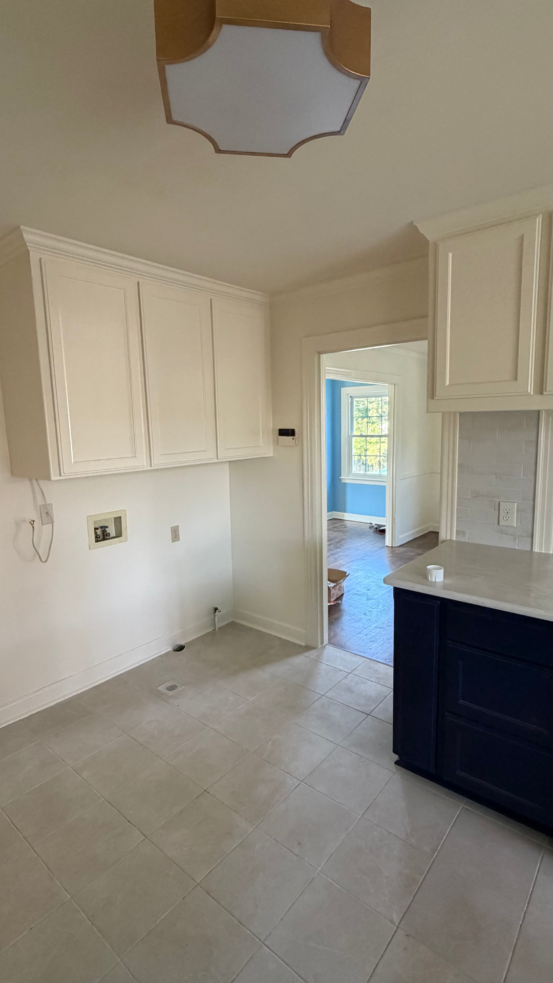 Fresh white kitchen walls and trim opening into a blue and white room